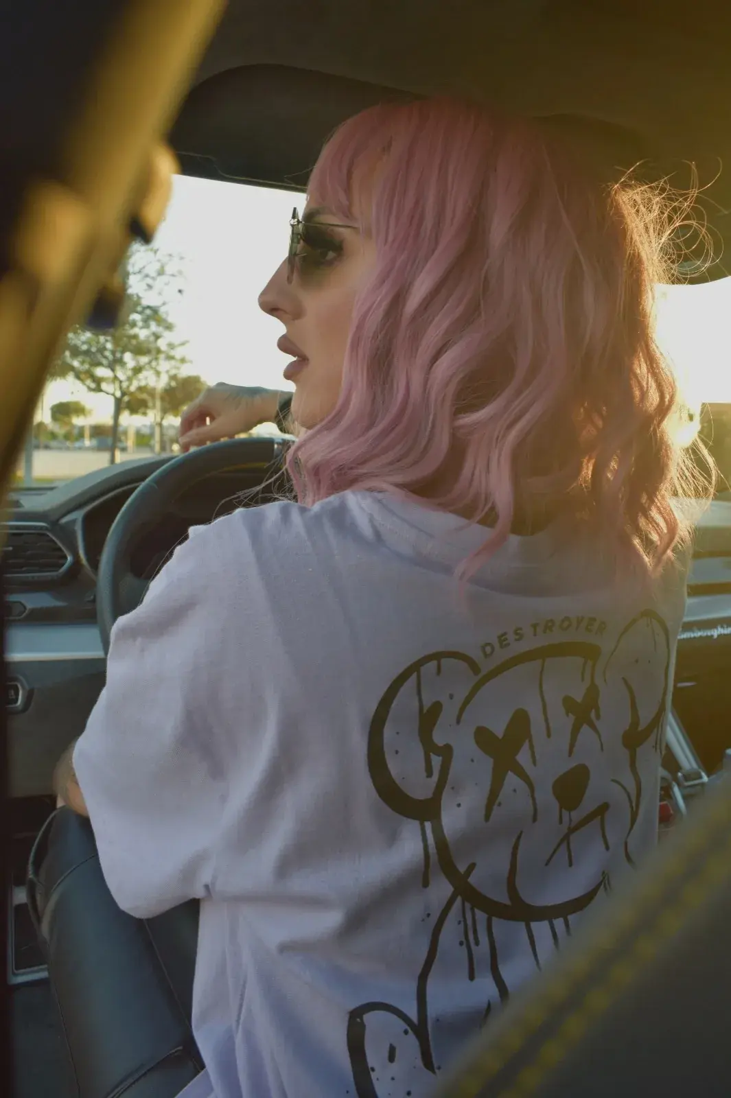 Modelo al volante con la camiseta lavanda, vista de espalda